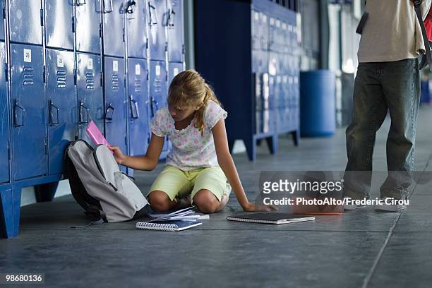 junior high student picking up dropped school supplies, boy standing by watching - junior high foto e immagini stock