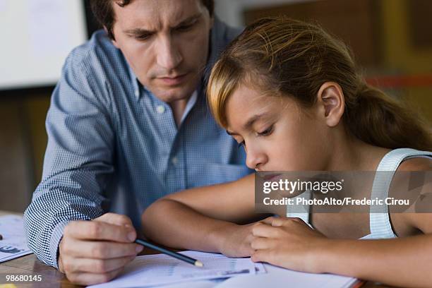 teacher helping elementary school student in class - learning difficulty stock pictures, royalty-free photos & images