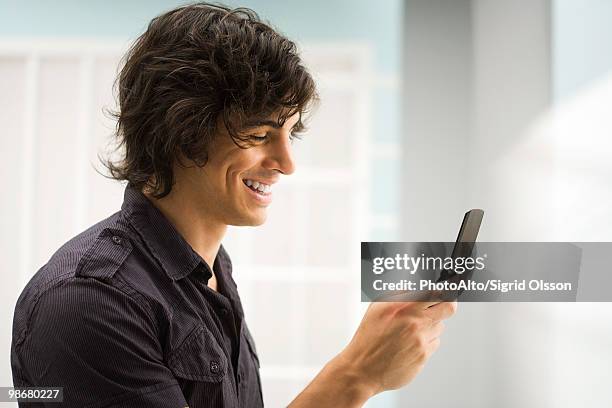 young man text messaging - feature phone stockfoto's en -beelden