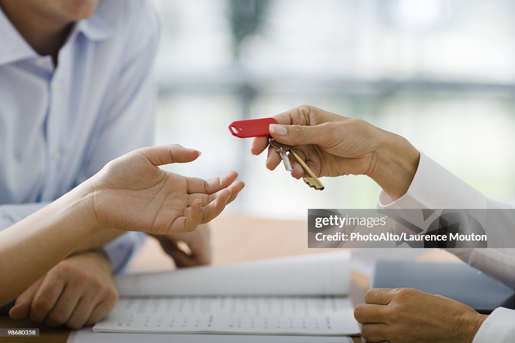 Hotel receptionist handing room key to guest