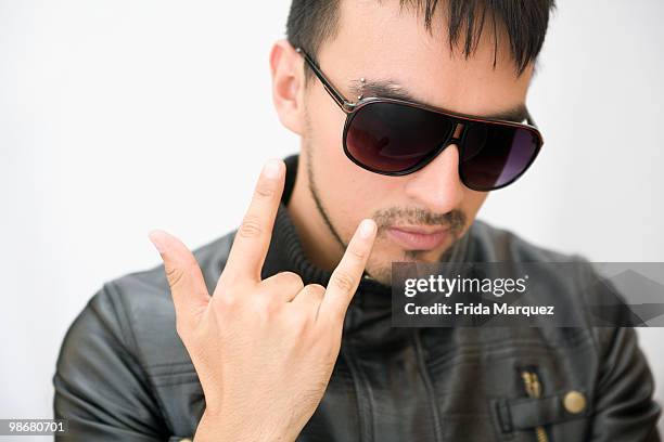 hispanic man in sunglasses and leather coat gesturing - ziegenbart stock-fotos und bilder