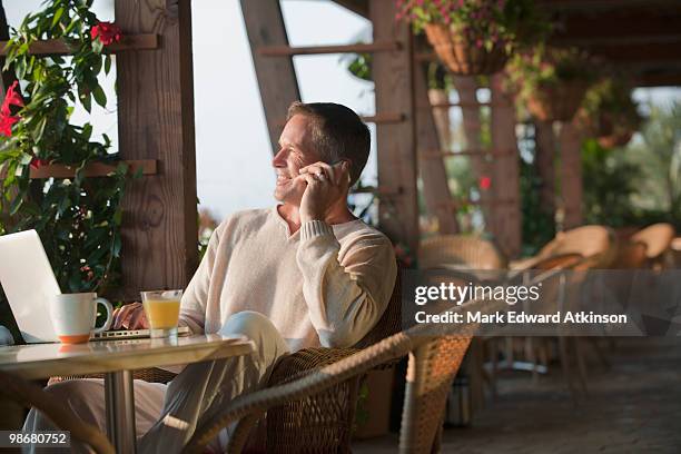 caucasian man talking on cell phone in restaurant - mesa cafeteria perfil fotografías e imágenes de stock