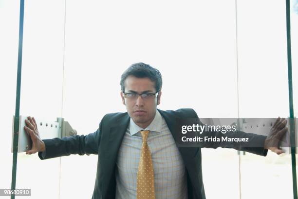 frowning hispanic businessman opening doors - blocking door stock pictures, royalty-free photos & images