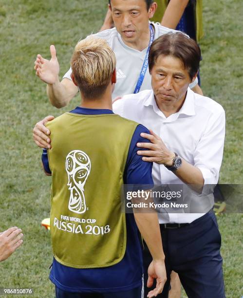 Japan coach Akira Nishino celebrates with player Keisuke Honda after Japan advanced to the last 16 of the World Cup in Russia despite a 1-0 defeat by...