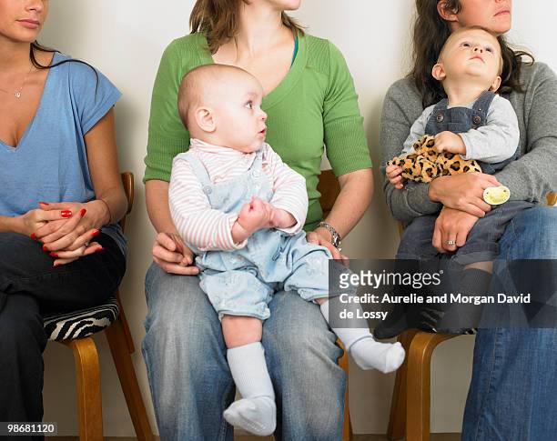 women and babies in waiting room - babies in a row stock pictures, royalty-free photos & images
