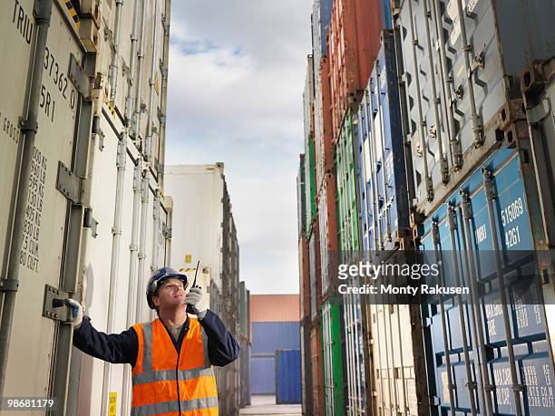 port worker with shipping containers - vrachtruimte stockfoto's en -beelden