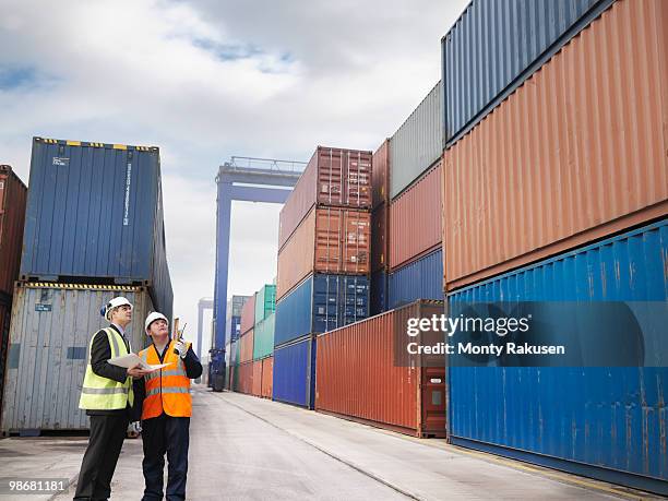 port workers with shipping containers - luggage hold stock pictures, royalty-free photos & images