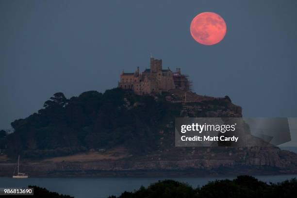 Full moon rises behind St Michael's Mount in Marazion near Penzance on June 28, 2018 in Cornwall, England. Tonight's strawberry moon, a name given to...