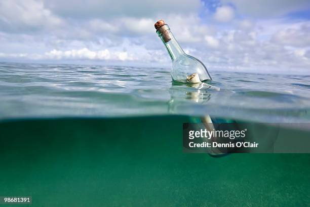 message in a bottle floating in ocean - flaschenpost stock-fotos und bilder