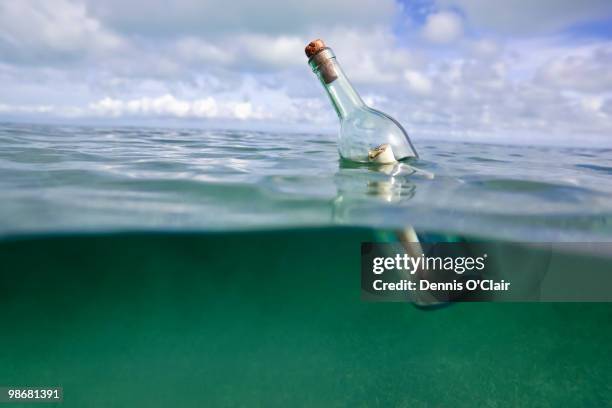 message in a bottle floating in ocean - message in a bottle floating in ocean stock pictures, royalty-free photos & images