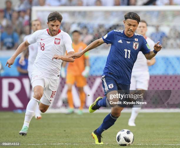 Japan's Takashi Usami dribbles the ball ahead of Poland's Bartosz Bereszynski during the first half of a World Cup group stage match at Volgograd...