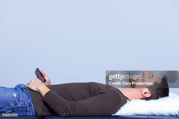 lying man listing to music, and singing - arts express yourself 2009 stock pictures, royalty-free photos & images