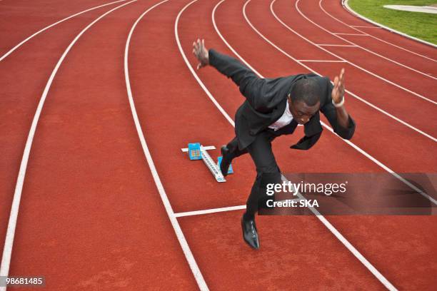businessman sprinting on running track - sprinting suit stock pictures, royalty-free photos & images