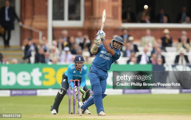 Kumar Sangakkara of Sri Lanka hits out during his innings of 112 watched by England's wicketkeeper Jos Buttler in the 4th Royal London One Day...