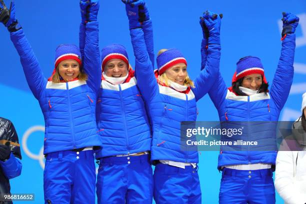 Norwegian gold medallists Ingvild Flugstad Oestberg , Astrid Uhrenholdt Jacobsen, Ragnhild Haga and Marit Bjoergen celebrate on the podium during the...