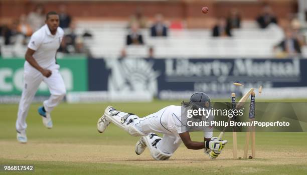 Nuwan Pradeep of Sri Lanka falls onto his stumps and is out hit wicket as England's Chris Jordan looks on during the 1st Test match between England...