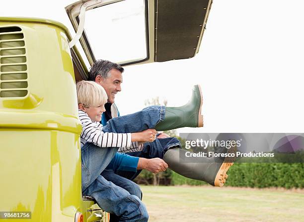 father and son putting on boots - boy kid playing cars stock pictures, royalty-free photos & images