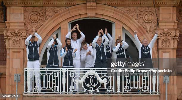 England players and coaches on the dressing room balcony applaud as England's Gary Ballance reaches his century during the 1st Test match between...