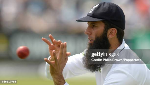 Moeen Ali of England catches a ball as the team warms up after the lunch break on day three of the 2nd Test match between England and Sri Lanka at...