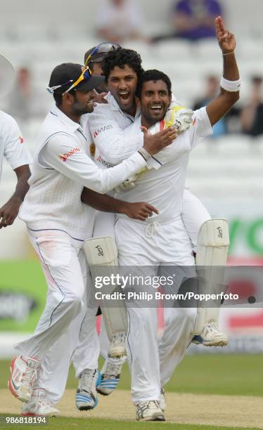 Dhammika Prasad of Sri Lanka is congratulated by teammates Dinesh Chandimal , Mahela Jayawardene and Lahiru Thirimanne after dismissing England's...