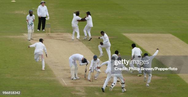 England's James Anderson despairs after losing England's last wicket and Sri Lanka's Kaushal Silva grabs a stump as Sri Lanka celebrate winning the...