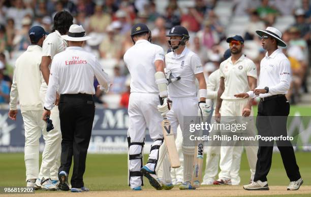 England's James Anderson tries to guide teammate Joe Root away from Ishant Sharma of India as they exchange words during the 1st Test match between...