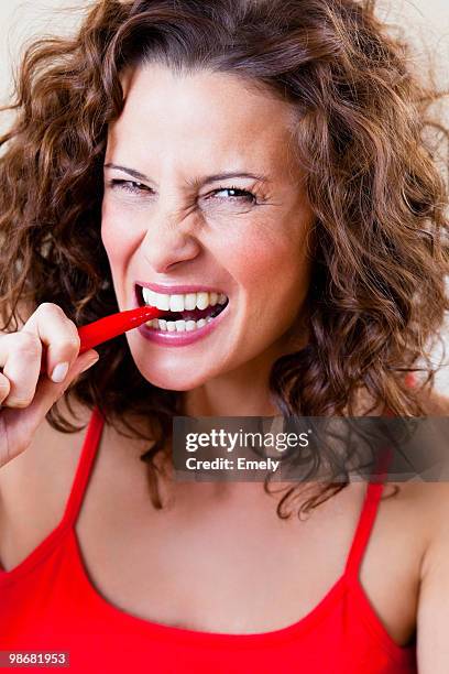 woman biting chili - female eating chili bildbanksfoton och bilder