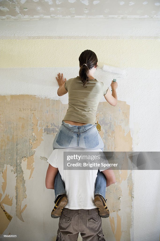 Young couple painting wall