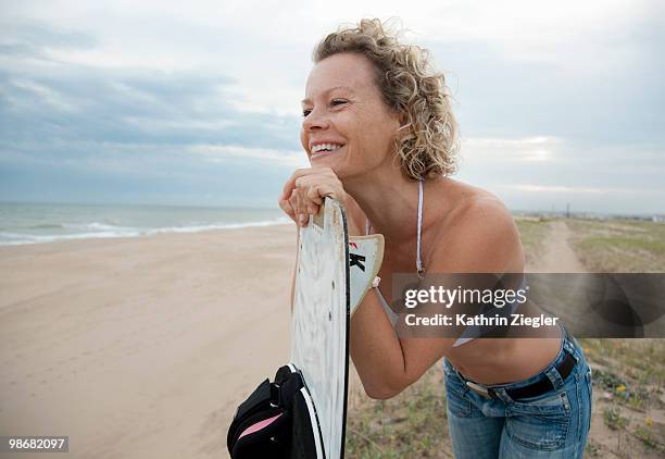 woman with kite board, overlooking beach - kathrin ziegler stockfoto's en -beelden