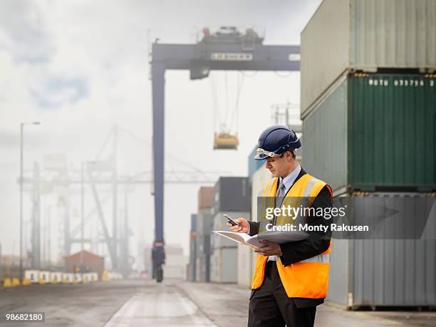 businessman in port with containers - vrachtruimte stockfoto's en -beelden