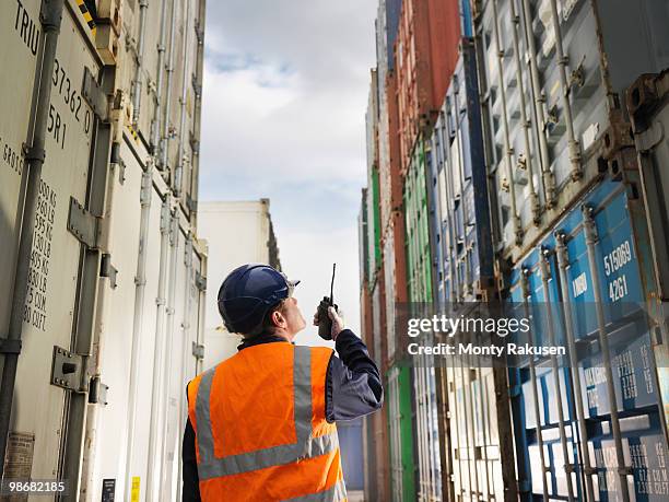 port worker with shipping containers - luggage hold stock pictures, royalty-free photos & images