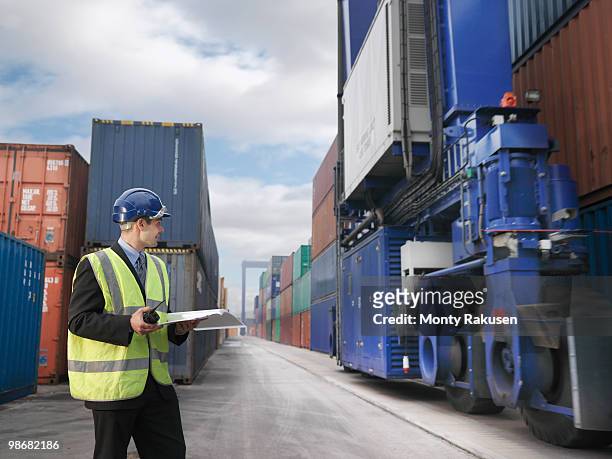 businessman with shipping containers - vrachtruimte stockfoto's en -beelden