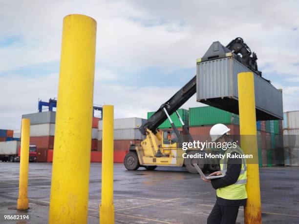 port workers with laptop and containers - luggage hold stock pictures, royalty-free photos & images