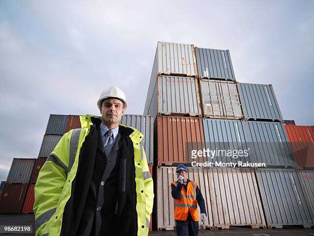 port workers with shipping containers - vrachtruimte stockfoto's en -beelden