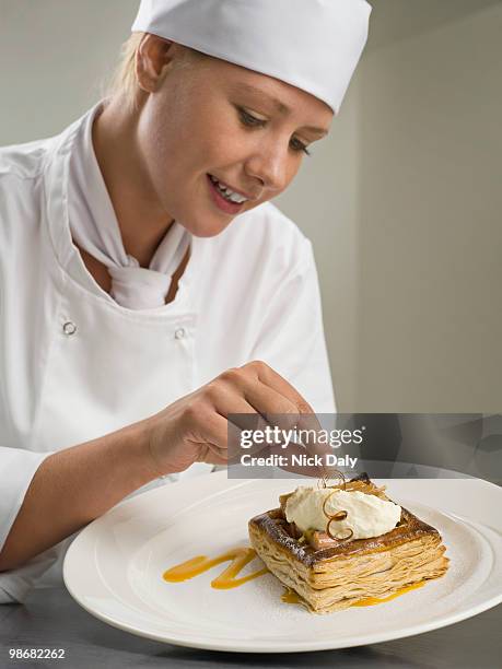 a female chef finishing a desert - food plating stock-fotos und bilder