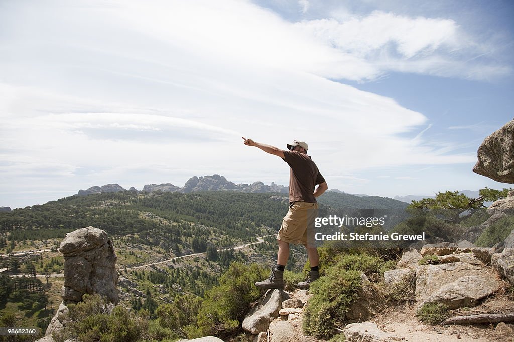 Man on a cliff pointing