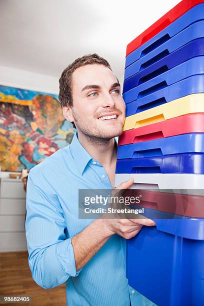 man carrying colored boxes - vrachtruimte stockfoto's en -beelden