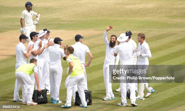 Moeen Ali of England is applauded by teammates and the crowd as he shows off the ball after taking his fifth wicket of India's 2nd innings of the 3rd...