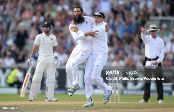 Moeen Ali of England celebrates with teammate Joe Root after dismissing India's Cheteshwar Pujara during the 4th Test match between England and India...