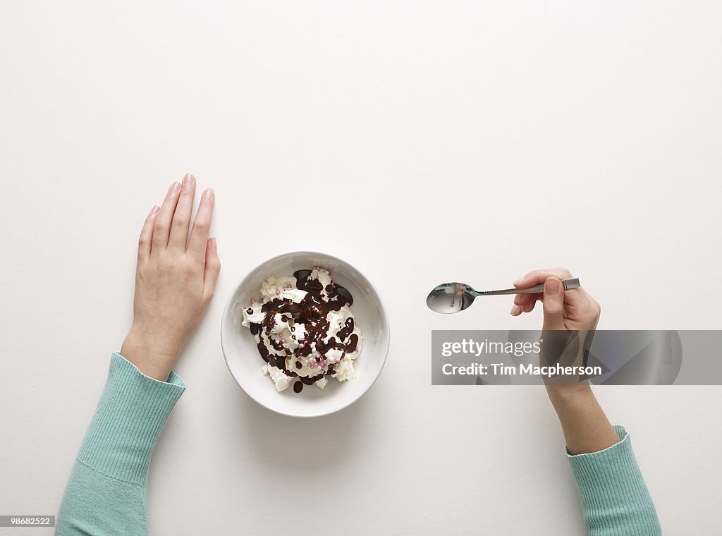 Hands by bowl of desert