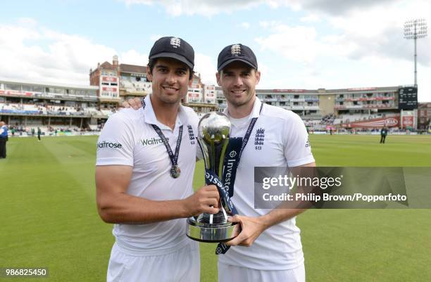 England captain Alastair Cook poses with teammate James Anderson and the Investec Series trophy after England won the 5th Test match between England...