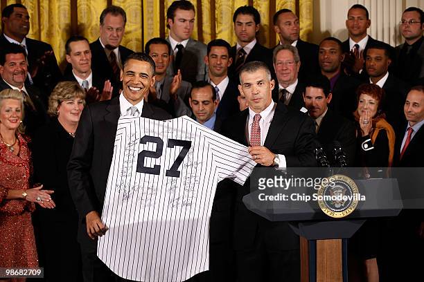 President Barack Obama is presented with an autographed New York Yankees jersey by team manager Joe Girardi during a ceremony celebrating the World...