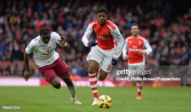 Chuba Akpom of Arsenal and Jores Okore of Aston Villa chase after the ball during the Barclays Premier League match between Arsenal and Aston Villa...