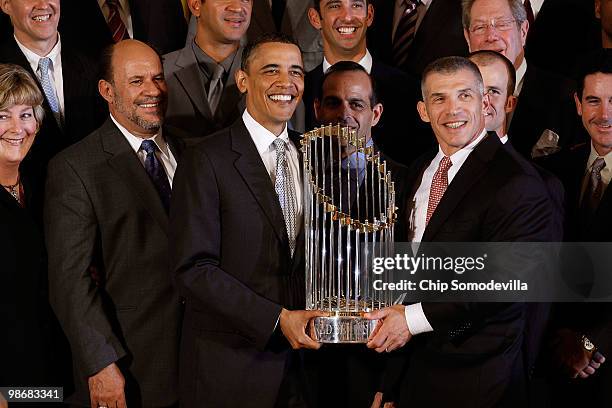 President Barack Obama and New York Yankees Manager Joe Girardi hold the Major League Baseball Commissioner's Trophy while posing for photographs...