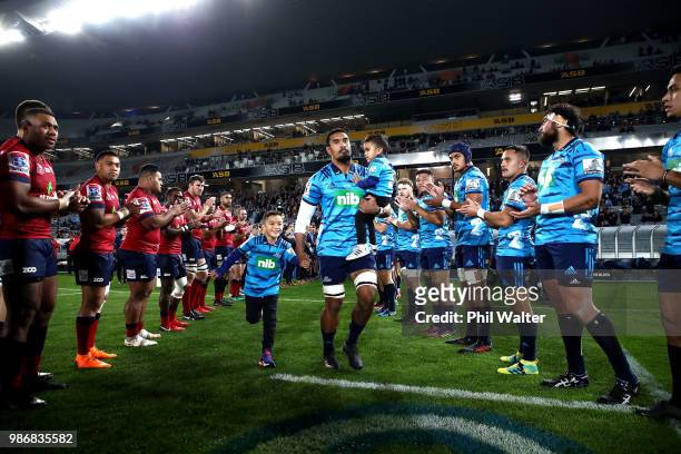 Jerome Kaino of the Blues runs out onto the field with his children during the round 17 Super Rugby match between the Blues and the Reds at Eden Park...
