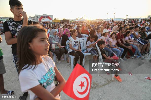 Little girl holds the flag of Tunisia as she attends a public viewing held in Mellassine, a popular neighbourhood of the capital Tunis located near...