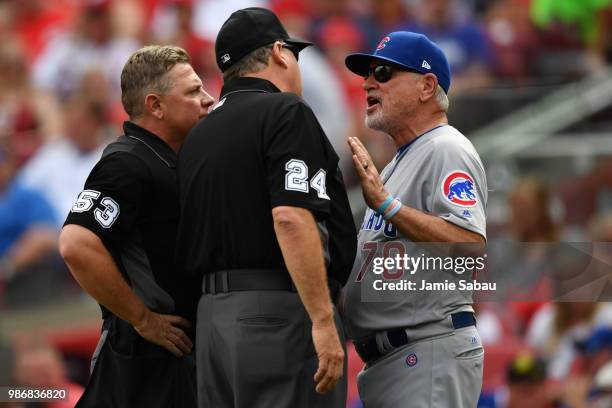 Manager Joe Maddon of the Chicago Cubs talks with umpires Greg Gibson and Jerry Layne during a game against the Cincinnati Reds at Great American...