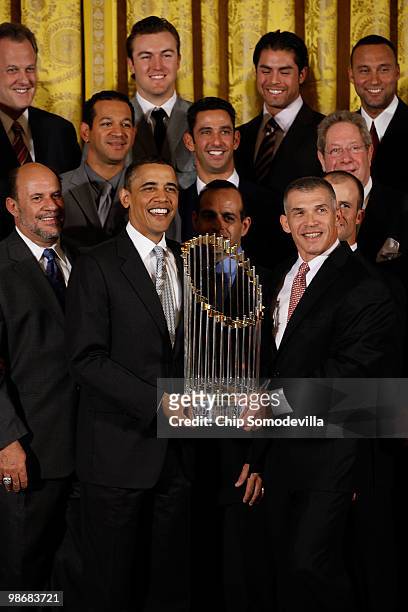 President Barack Obama and New York Yankees Manager Joe Girardi hold the Major League Baseball Commissioner's Trophy while posing for photographs...
