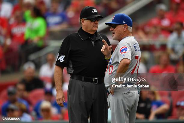 Manager Joe Maddon of the Chicago Cubs talks with umpire Jerry Layne during a game against the Cincinnati Reds at Great American Ball Park on June...