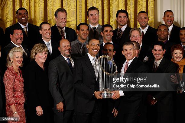 President Barack Obama and New York Yankees Manager Joe Girardi hold the Major League Baseball Commissioner's Trophy while posing for photographs...